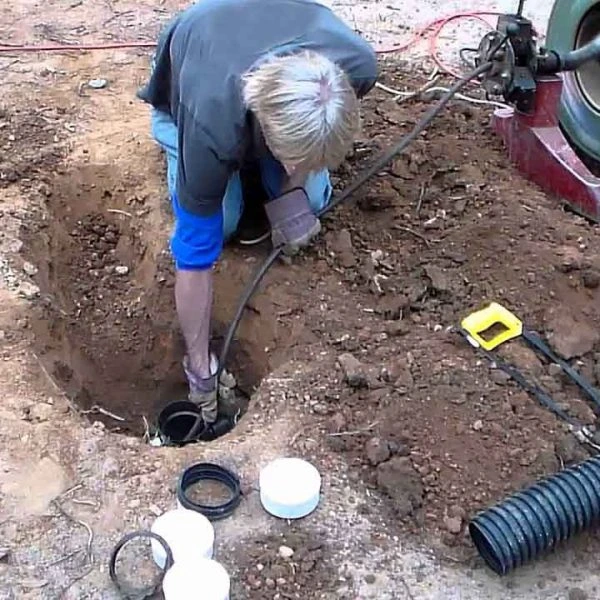 Plumber running a sewer camera through a pipe to inspect for cracks and damage